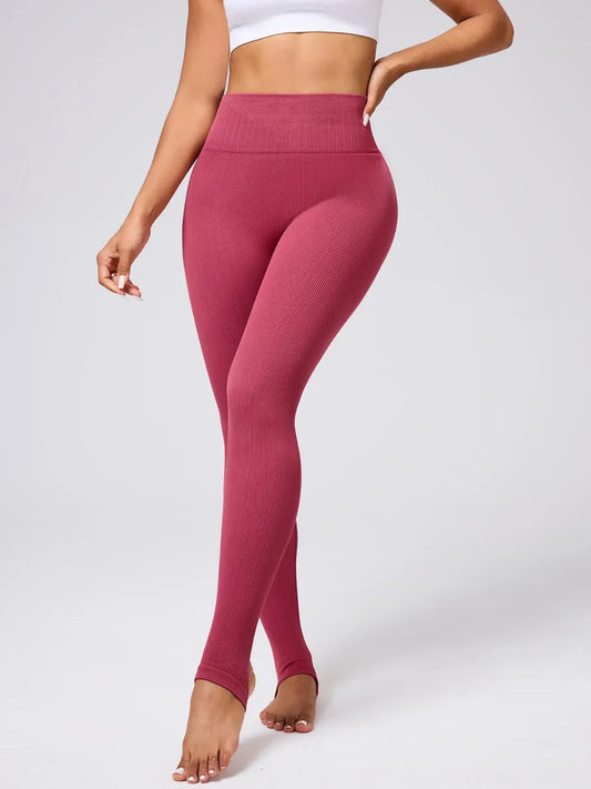 Model wearing women’s high-waist stirrup leggings with foot straps from Flexline, sculpting workout tights